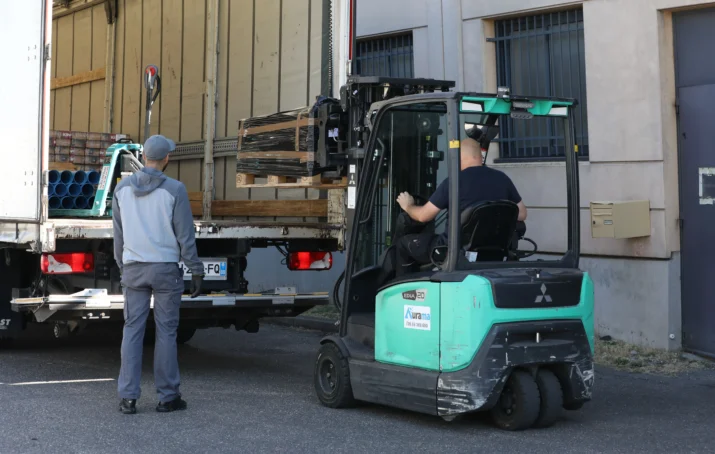 Chariot déposant un colis dans un camion de livraison